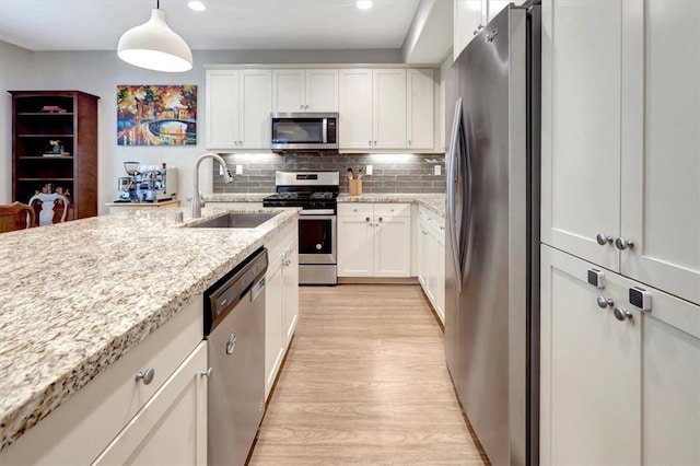 10561 Cannon Dr, Rancho Cucamonga, CA 91730 - kitchen featuring appliances with stainless steel finishes, a sink, light wood finished floors, recessed lighting, and white cabinets