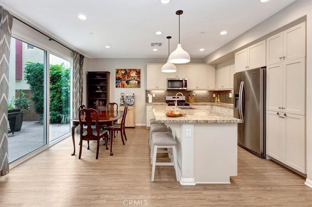 10561 Cannon Dr, Rancho Cucamonga, CA 91730 - kitchen with appliances with stainless steel finishes, a sink, light wood-style flooring, backsplash, and recessed lighting