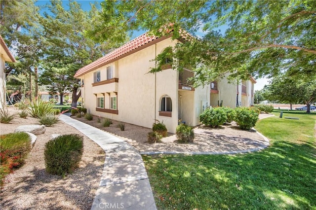 9653 Spyglass Ave Unit 99, Desert Hot Springs, CA 92240 - view of property exterior with a lawn, a tile roof, and stucco siding
