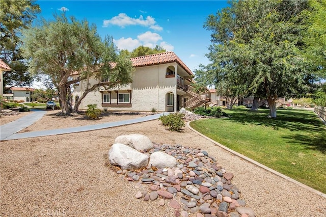 9653 Spyglass Ave Unit 99, Desert Hot Springs, CA 92240 - view of front of house with stucco siding, a front yard, and a tile roof