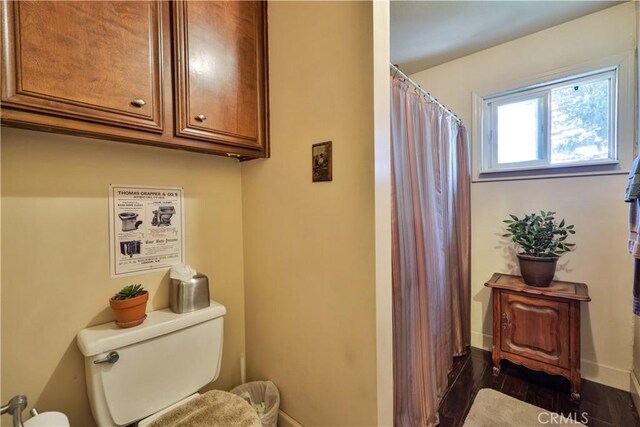 22972 Valley View Dr, Crestline, CA 92325 - full bathroom with wood finished floors, toilet, curtained shower, and baseboards