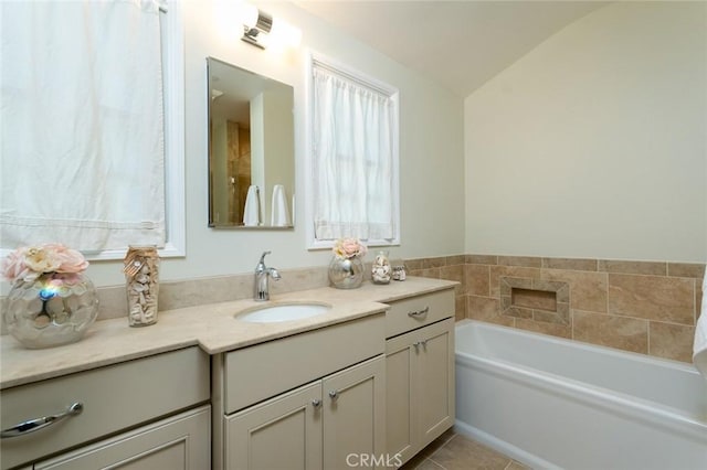 full bath featuring vanity, a bath, tile patterned flooring, and lofted ceiling