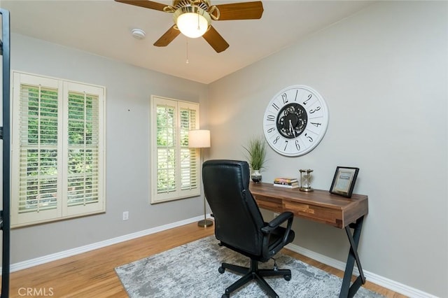 office featuring wood finished floors, baseboards, and a ceiling fan