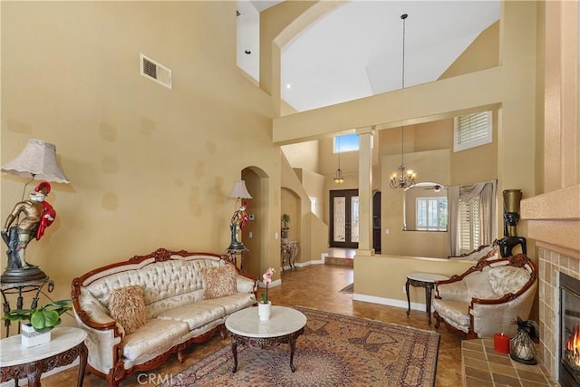 44886 Camino Veste, Temecula, CA 92592 - living room with high vaulted ceiling, a tile fireplace, arched walkways, baseboards, and a chandelier