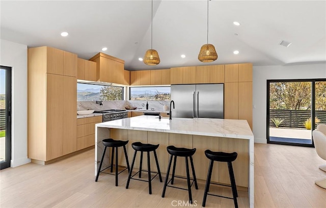 820 Calle Mendoza, San Clemente, CA 92672 - kitchen with high end appliances, vaulted ceiling, light wood-style flooring, a kitchen island with sink, and modern cabinets