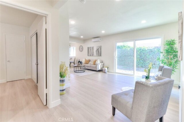 16928 Pocono St, La Puente, CA 91744 - living room with a wall mounted air conditioner, light wood-style flooring, recessed lighting, and baseboards