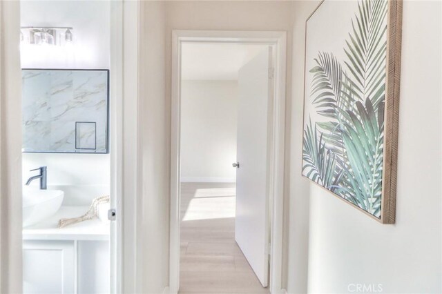 16928 Pocono St, La Puente, CA 91744 - hallway featuring light wood finished floors and a sink