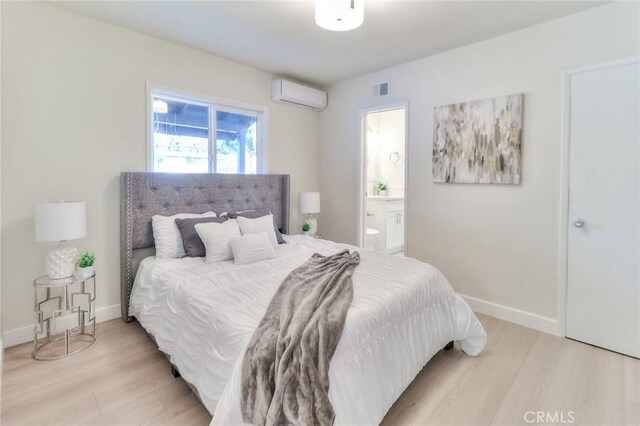 16928 Pocono St, La Puente, CA 91744 - bedroom with a wall mounted air conditioner, light wood-style floors, baseboards, and connected bathroom