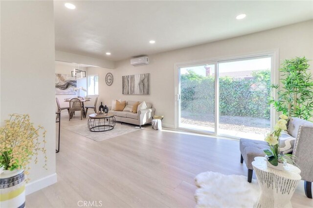 16928 Pocono St, La Puente, CA 91744 - living area featuring an AC wall unit, light wood finished floors, recessed lighting, and baseboards