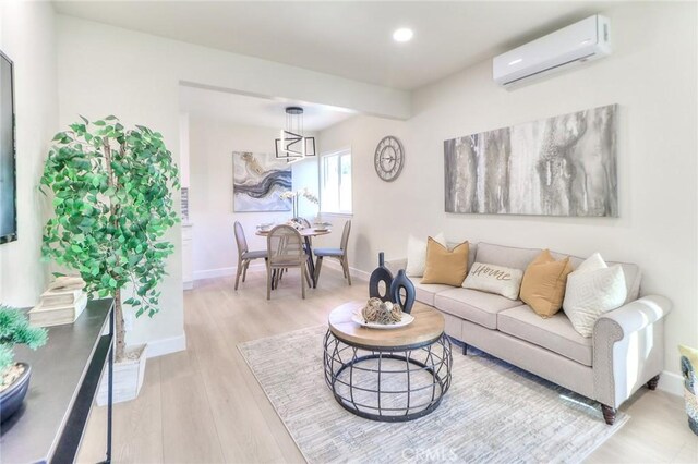 16928 Pocono St, La Puente, CA 91744 - living area with a wall unit AC, recessed lighting, light wood finished floors, baseboards, and a chandelier