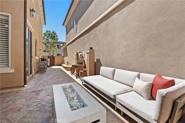 view of patio featuring an outdoor living space with a fire pit