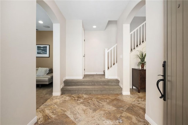 entrance foyer with stairway, arched walkways, marble finish floors, baseboards, and recessed lighting