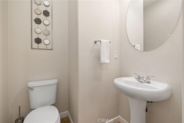 half bathroom with toilet and baseboards