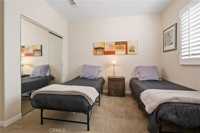 carpeted bedroom with a closet and baseboards