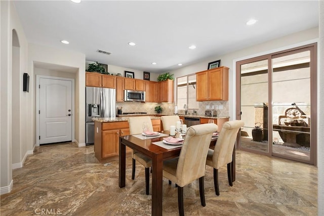 dining area with marble tiled flooring, baseboards, recessed lighting, and arched walkways