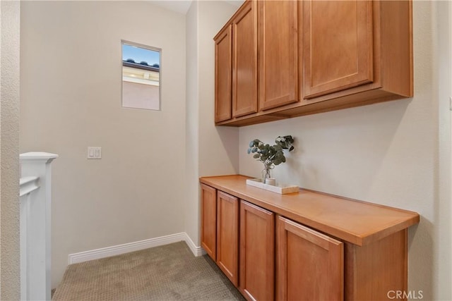 interior space featuring light colored carpet and baseboards