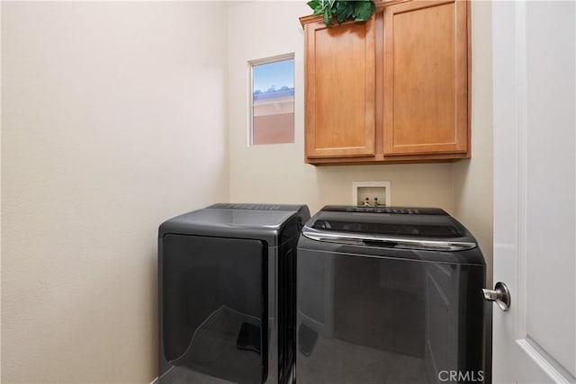 washroom with washer and dryer and cabinet space