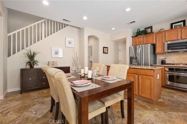 dining space with arched walkways, recessed lighting, and baseboards