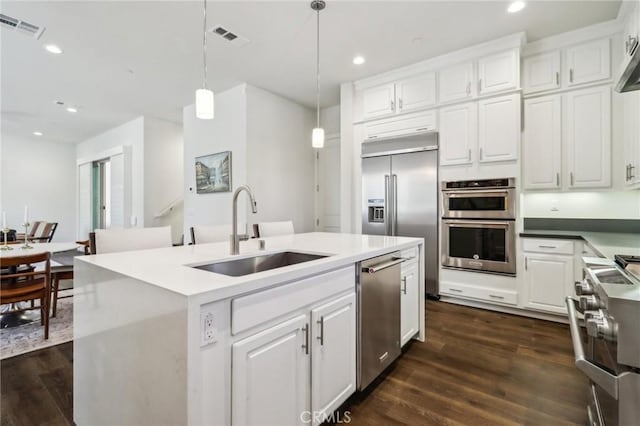 132 Interval, Irvine, CA 92618 - kitchen with a sink, high quality appliances, a center island with sink, dark wood-style floors, and recessed lighting