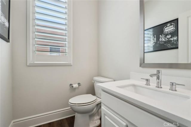 132 Interval, Irvine, CA 92618 - half bathroom featuring vanity, toilet, wood finished floors, and baseboards
