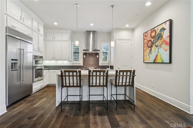 132 Interval, Irvine, CA 92618 - kitchen with appliances with stainless steel finishes, wall chimney range hood, white cabinets, dark wood finished floors, and recessed lighting