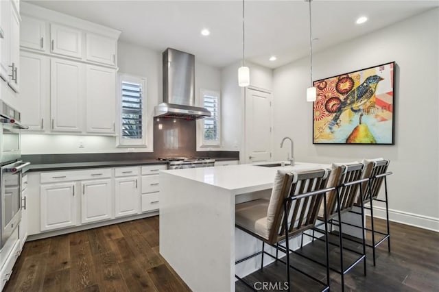 132 Interval, Irvine, CA 92618 - kitchen featuring wall chimney exhaust hood, dark wood finished floors, recessed lighting, an island with sink, and white cabinets