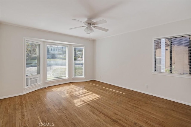 unfurnished room with a ceiling fan, wood finished floors, baseboards, and cooling unit