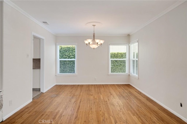 empty room featuring a chandelier, light wood-style floors, baseboards, and ornamental molding