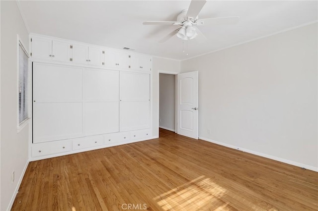 spare room with baseboards, light wood-style floors, and ceiling fan