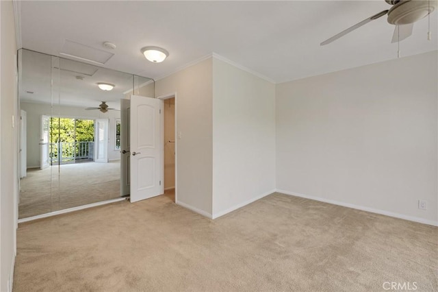 unfurnished room with carpet flooring, a ceiling fan, baseboards, a smoke detector, and crown molding