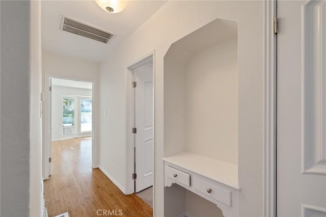 mudroom with light wood finished floors and baseboards