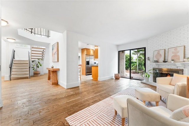15 Firestone Unit 4, Irvine, CA 92614 - living area featuring stairs, light wood-style flooring, a fireplace, and baseboards