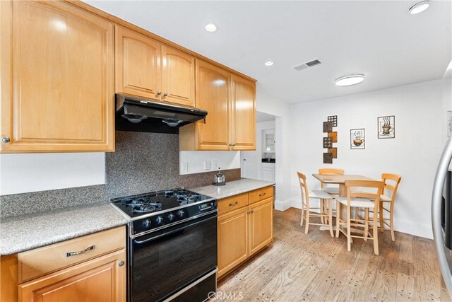 15 Firestone Unit 4, Irvine, CA 92614 - kitchen with gas stove, under cabinet range hood, baseboards, light wood-style flooring, and recessed lighting