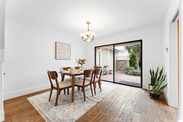 15 Firestone Unit 4, Irvine, CA 92614 - dining space featuring a chandelier, light wood-type flooring, and baseboards