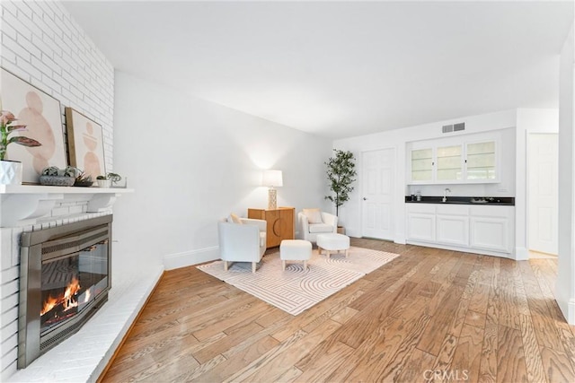 15 Firestone Unit 4, Irvine, CA 92614 - living area with a fireplace and light wood-style floors