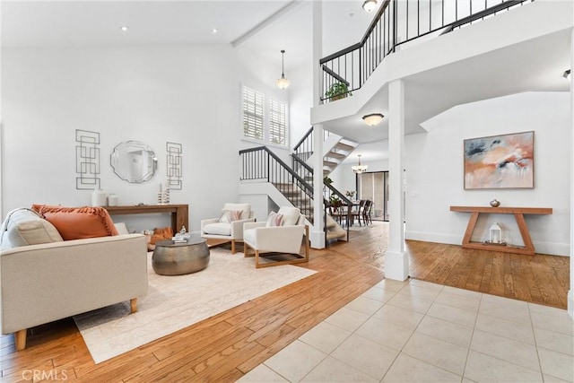 15 Firestone Unit 4, Irvine, CA 92614 - living room featuring stairs, hardwood / wood-style flooring, high vaulted ceiling, and baseboards