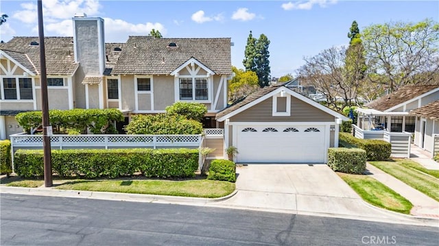15 Firestone Unit 4, Irvine, CA 92614 - tudor house with a chimney, concrete driveway, stucco siding, and a garage
