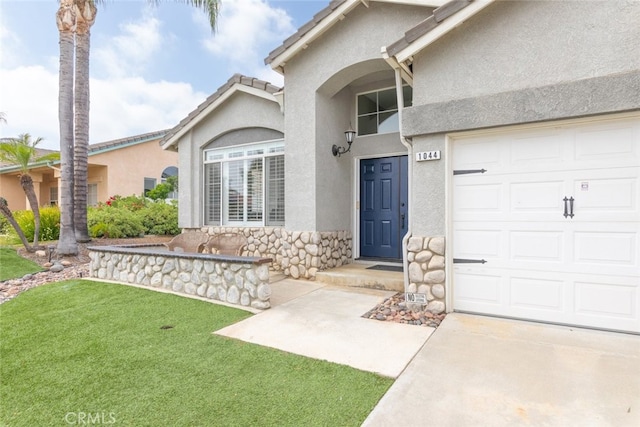 1044 Shadow Crest Cir, Corona, CA 92881 - view of exterior entry with stucco siding, a yard, concrete driveway, and stone siding