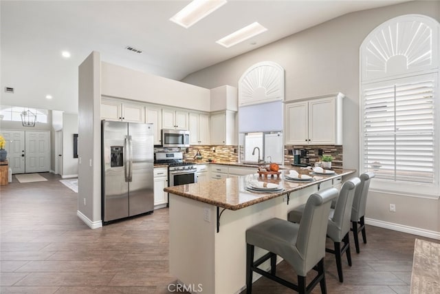 1044 Shadow Crest Cir, Corona, CA 92881 - kitchen with stainless steel appliances, backsplash, a peninsula, light stone countertops, and a kitchen bar