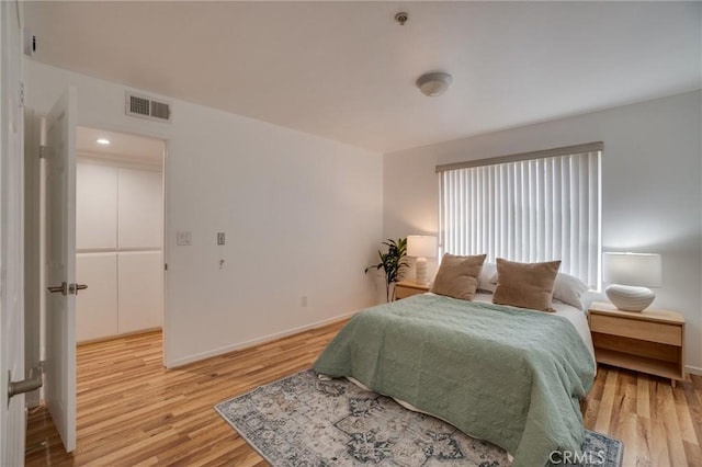 bedroom featuring light wood finished floors and baseboards