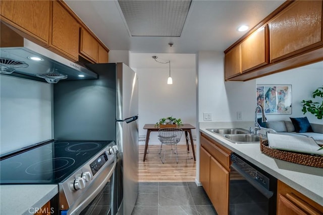 kitchen featuring stainless steel electric range oven, black dishwasher, a sink, light countertops, and brown cabinetry