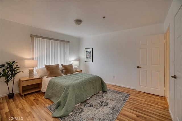 bedroom with light wood-type flooring and baseboards
