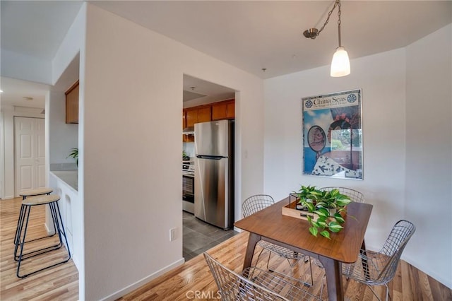 dining space with light wood finished floors and baseboards