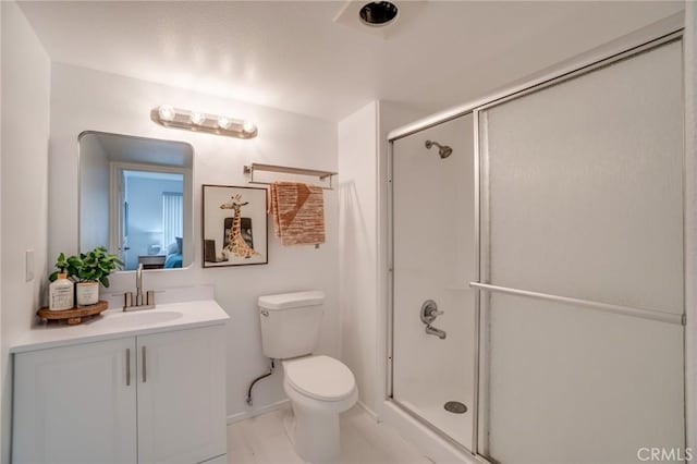 bathroom featuring a shower stall, toilet, vanity, and baseboards