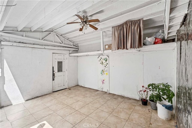 below grade area featuring ceiling fan and tile patterned floors