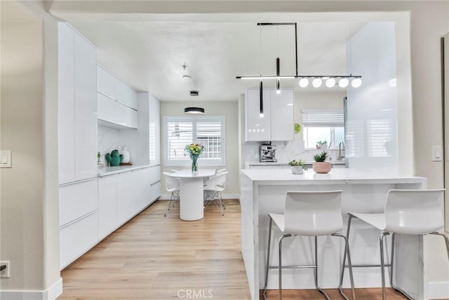 166 Alta St Unit B, Arcadia, CA 91006 - kitchen with modern cabinets, white cabinets, a breakfast bar, light wood finished floors, and plenty of natural light