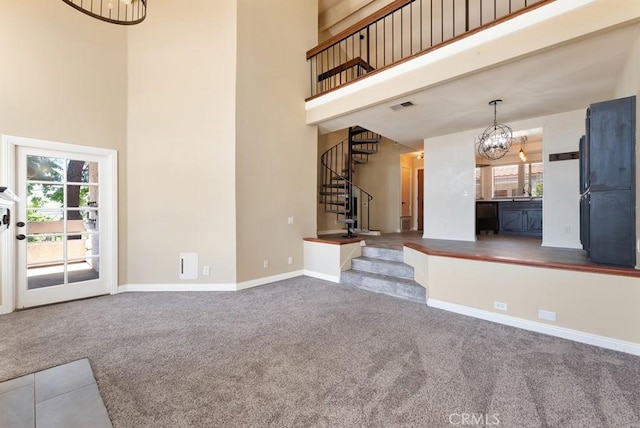3306 Darby St Unit 402, Simi Valley, CA 93063 - unfurnished living room featuring a towering ceiling, carpet, a chandelier, stairs, and baseboards