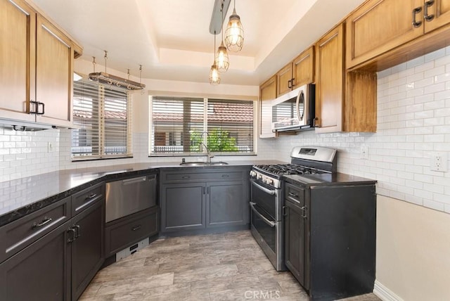 3306 Darby St Unit 402, Simi Valley, CA 93063 - kitchen with appliances with stainless steel finishes, a sink, a raised ceiling, and tasteful backsplash