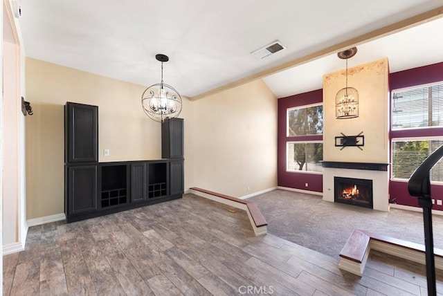 3306 Darby St Unit 402, Simi Valley, CA 93063 - unfurnished living room featuring a chandelier, wood finished floors, a lit fireplace, baseboards, and vaulted ceiling