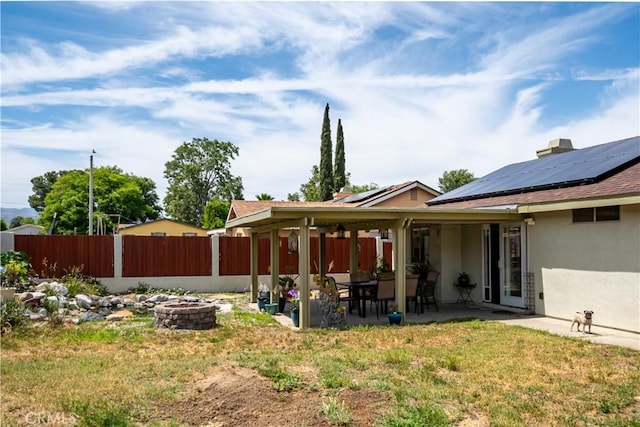18993 Janisse Ln, Lake Elsinore, CA 92530 - rear view of property with stucco siding, an outdoor fire pit, solar panels, and a patio